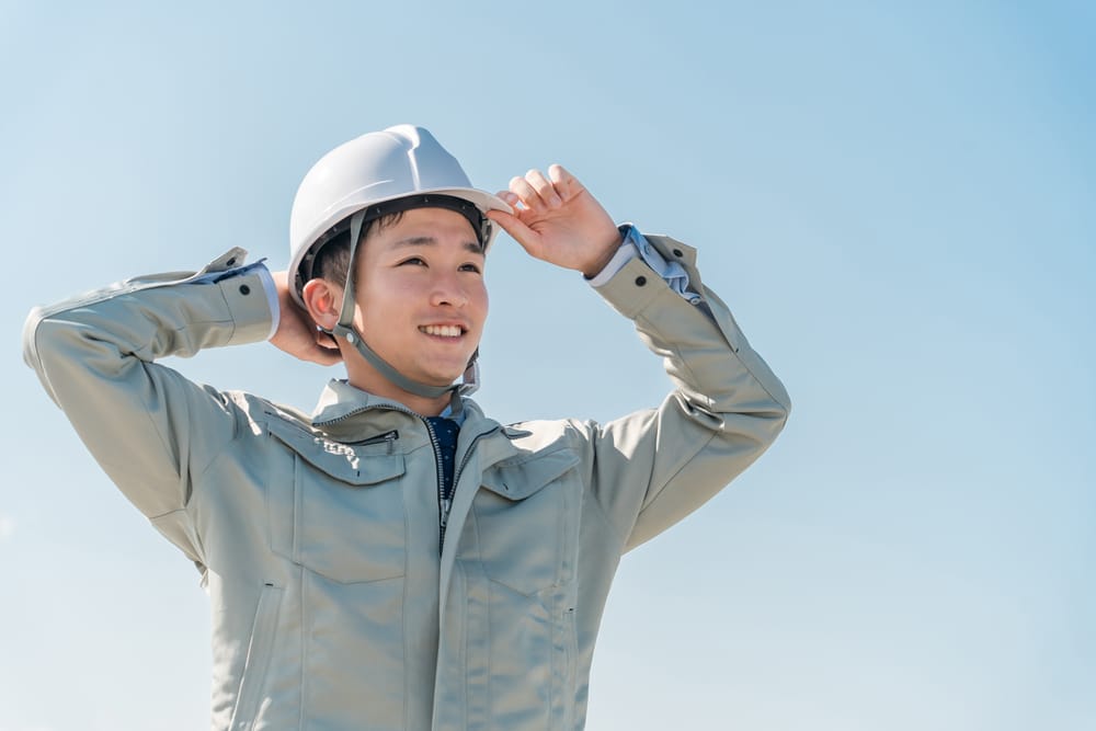 ヘルメットをかぶり空を見上げる社員
